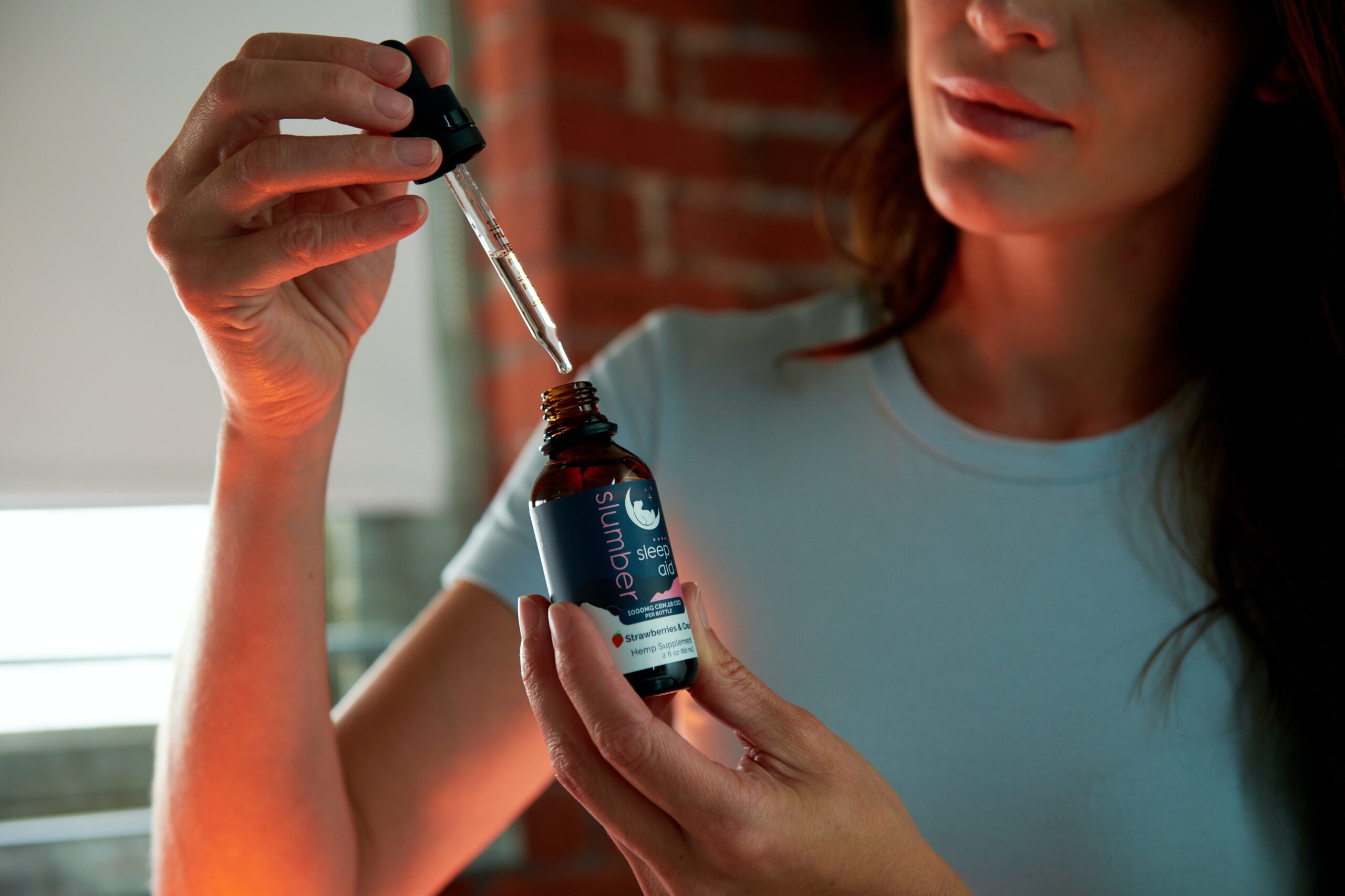 a woman holding a bottle of essential oil