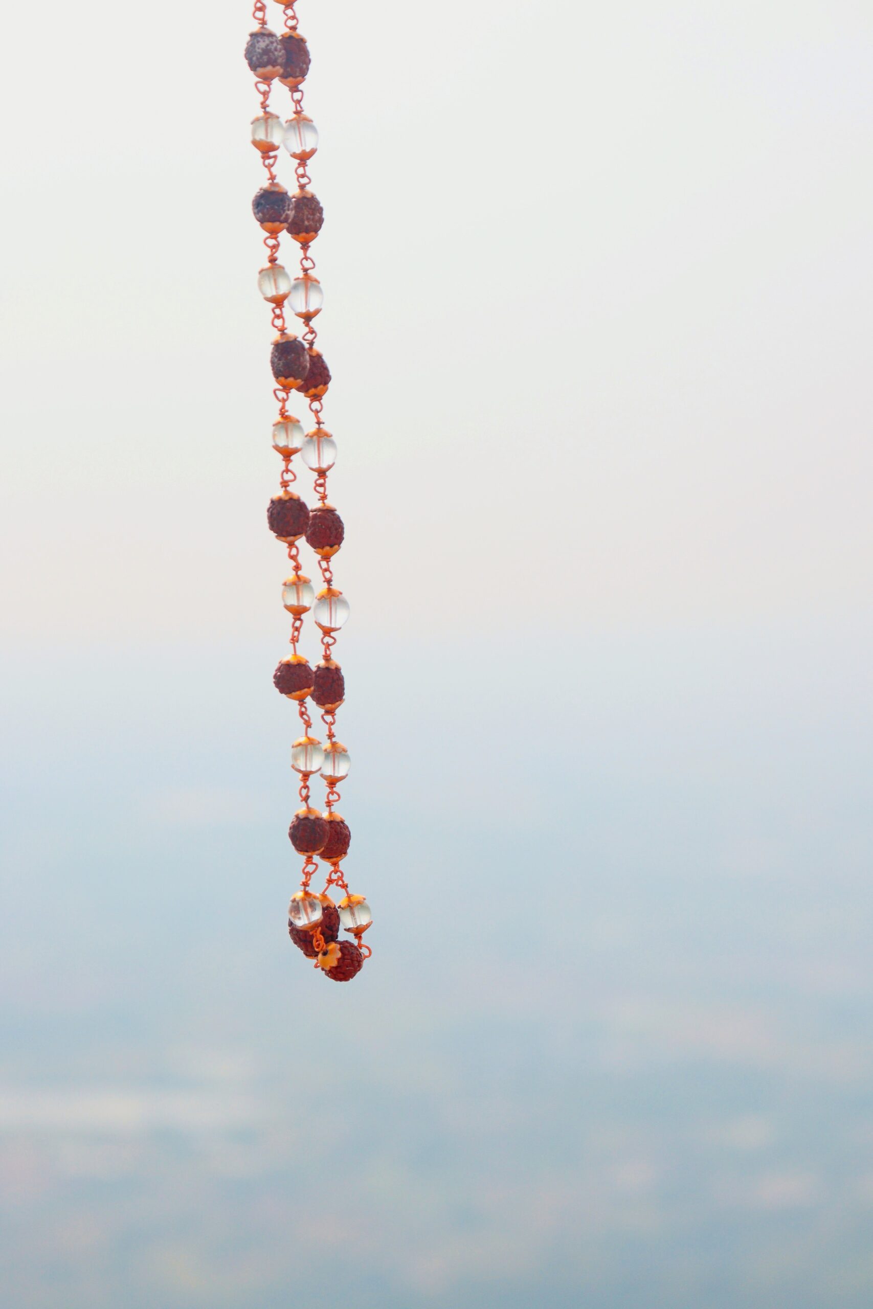 a long beaded necklace hanging from the side of a window
